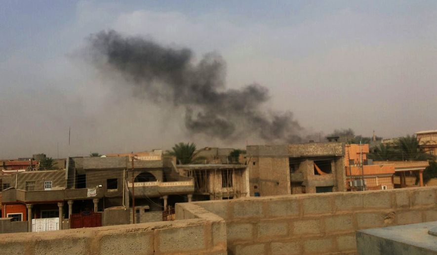Smoke plumes are visible over buildings in the Iraqi town of Hit, in western Anbar province - 140 kilometers (85 miles) west of Baghdad - after an attack by the al-Qaida-inspired Islamic State group, Sunday, Oct. 5, 2014. The Islamic State group stormed Hit on Thursday, its latest victory against the embattled Iraqi military in Anbar province. (AP Photo)