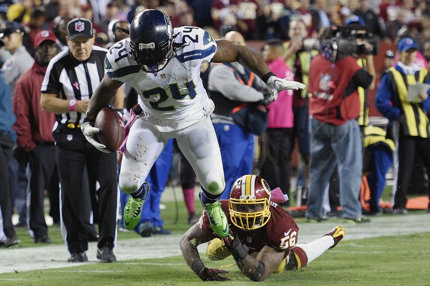Seattle Seahawks running back Marshawn Lynch (24) breaks a tackle by Washington Redskins inside linebacker Perry Riley (56) on his way to a touchdown during the second half of an NFL football game in Landover, Md., Monday, Oct. 6, 2014. (AP Photo/Nick Wass)