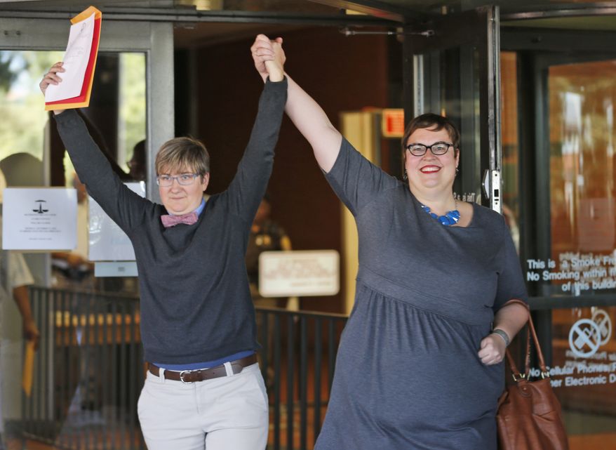 Nicole Pries, left, and Lindsey Oliver hold up their marriage license as they celebrate being one of the first same-sex couples in Virginia to be married outside a Richmond court building in Richmond, Va., Monday, Oct. 6, 2014. The Supreme Court's order turning way appeals from five states seeking to prohibit same-sex marriage has triggered a series of moves in affected states to clear the way for gay and lesbian unions. (Associated Press)