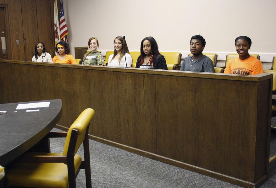In this Sept. 19, 2014 photo, Stephenson County Peer Jury coordinator Jacqueline Cooley, left, sits in a jury box at the Stephenson County Courthouse in Freeport, Ill., with peer jury volunteers, from left, Lisa Spangler, Jorie Heilman, Haley Pentecost, Talani Grier, Raekwon Cooley and Mariah Coffee. The Stephenson County Peer Jury Program established by the State’s Attorney’s office in 2007, allows Freeport-area youth who are 13 to 17 years old to serve as a peer jury in criminal cases involving first-time juvenile offenders. (AP Photo/The Journal-Standard, Shannon Ireland)