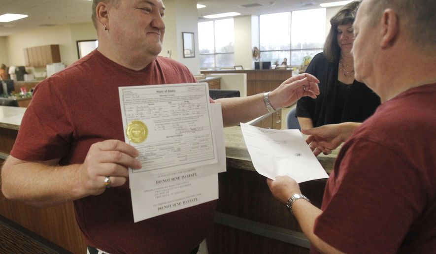 Don Moline holds up their marriage license as he embraces his partner Clint Newlan Wednesday morning, Oct. 8, 2014, at Twin Falls County West in Twin Falls, Idaho. U.S. Supreme Court Justice Anthony Kennedy has temporarily blocked an appeals court ruling that declared gay marriage legal in the states of Idaho and Nevada. The order came minutes after Idaho on Wednesday filed an emergency request for an immediate stay. (AP Photo/The Times-News, Drew Nash) MANDATORY CREDIT