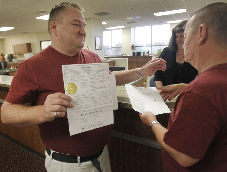 Don Moline holds up their marriage license as he embraces his partner Clint Newlan Wednesday morning, Oct. 8, 2014, at Twin Falls County West in Twin Falls, Idaho. U.S. Supreme Court Justice Anthony Kennedy has temporarily blocked an appeals court ruling that declared gay marriage legal in the states of Idaho and Nevada. The order came minutes after Idaho on Wednesday filed an emergency request for an immediate stay. (AP Photo/The Times-News, Drew Nash) MANDATORY CREDIT