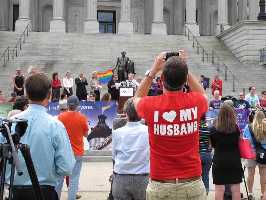 Trevor Donovan takes pictures at a Statehouse rally on Wednesday, Oct. 8, 2014, in Columbia, S.C. Supporters of gay marriage held a rally at the capitol the same day a Charleston County Probate judge approved an application for a same-sex marriage license. (AP Photo/Jeffrey Collins)