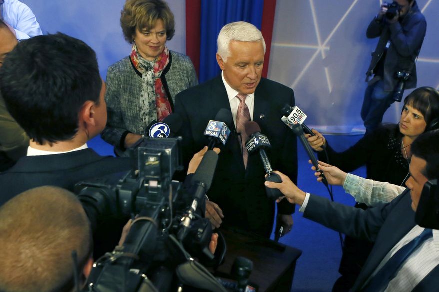 Republican Governor Tom Corbett, center, stands with his wife Susan, as he answers questions after a debate with Democratic party candidate for governor of Pennsylvania, Tom Wolf at the WTAE-TV studio in Wilkinsburg, Pa. on Wednesday, Oct. 8, 2014. (AP Photo/Keith Srakocic)