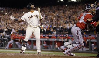San Francisco Giants Pablo Sandoval watches after a pitch went wild as he signals to Joe Panik on third to come in to score in the seventh inning against the Washington Nationals during Game 4 of baseball&#39;s NL Division Series in San Francisco, Tuesday, Oct. 7, 2014. (AP Photo/Ben Margot)