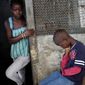 In this photo taken Sunday, Sept. 28, 2014, Promise Cooper, 16, Emmanuel Junior Cooper, 11, and Benson Cooper, 15, sit at their St. Paul Bridge home in Monrovia, Liberia. The Cooper children are now orphans, having lost their mother Princess in July, and their father Emmanuel in August. Their 5-month-old baby brother Success also succumbed to the virus in August. Ruth, their 13-year-old sister is being hospitalized with Ebola. The three never fell sick to the deadly disease. (AP Photo/Jerome Delay)