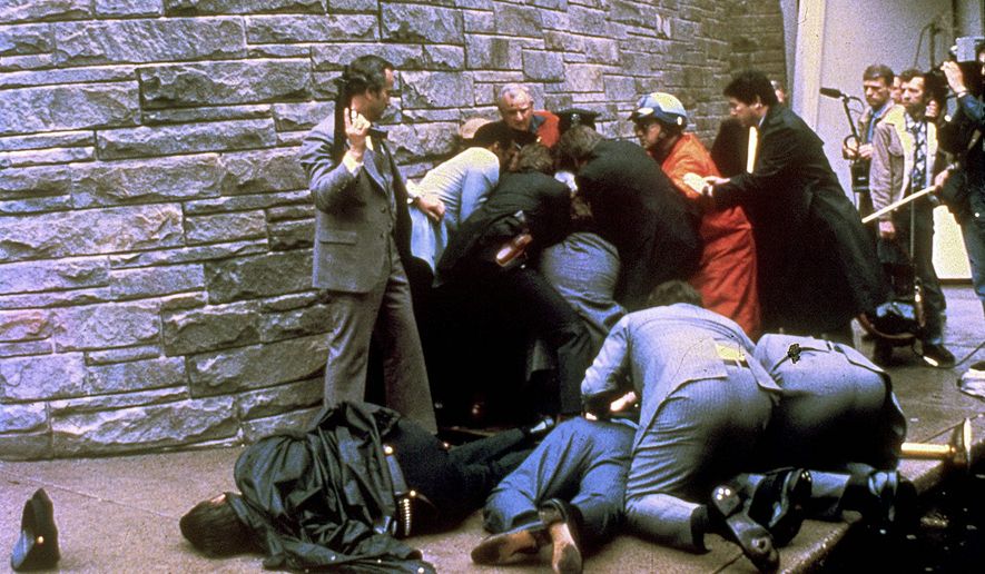 Secret Service agents restrain John W. Hinkley Jr. in the aftermath of his shooting President Reagan outside the Washington Hilton. (Associated Press)