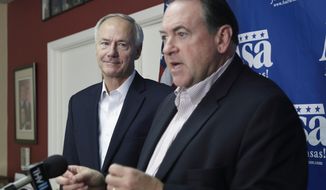 Republican candidate for Arkansas governor Asa Hutchinson, left, listens as former Arkansas Gov. Mike Huckabee speaks during a news conference at Republican Party of Arkansas headquarters in Little Rock, Ark., Thursday, Oct. 9, 2014. Huckabee is campaigning for Republicans on his home turf, finding that a political landscape that had been dominated by Democrats since Reconstruction is now a two-party state. (AP Photo/Danny Johnston)
