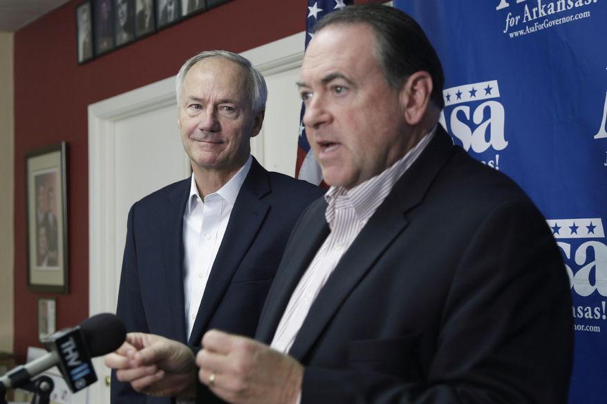 Republican candidate for Arkansas governor Asa Hutchinson, left, listens as former Arkansas Gov. Mike Huckabee speaks during a news conference at Republican Party of Arkansas headquarters in Little Rock, Ark., Thursday, Oct. 9, 2014. Huckabee is campaigning for Republicans on his home turf, finding that a political landscape that had been dominated by Democrats since Reconstruction is now a two-party state. (AP Photo/Danny Johnston)
