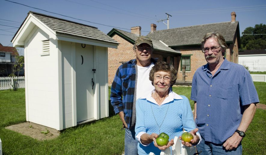 ADVANCE FOR USE SUNDAY, OCT. 12 AND THEREAFTER - In this Sept. 17, 2014 photo, Richard Dombroski, MaryLouise Agnew and Terry Buckaloo stand with the tomatoes that were harvested from the 150-year-old heirloom tomato seeds found in the privy of the Lincoln-Manahan Home in Sterling, Ill. (AP Photo/Sauk Valley Media, Philip Marruffo)