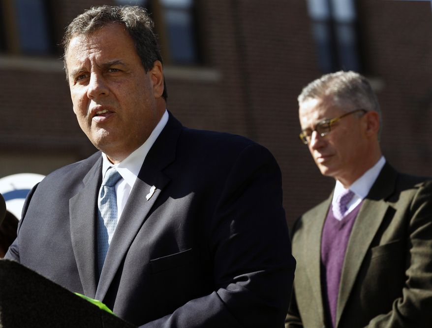 Former Gov. Jim McGreevey, right, listens as Gov. Chris Christie addresses a gathering about plans for better treatment for those in the state with addiction and mental health problems Thursday, Oct. 9, 2014, in Trenton, N.J. When he's not campaigning for politicians elsewhere, Christie has often been campaigning in New Jersey for more services for people with addictions. (AP Photo/Mel Evans)