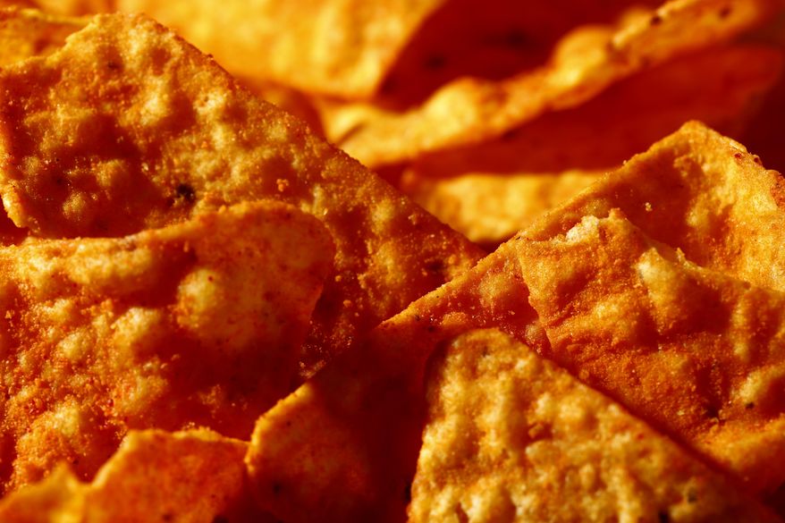 This Sept. 26, 2014 photo shows Nacho Cheese flavored Doritos in Philadelphia. “Artificial and natural flavors” have become ubiquitous terms on food labels, helping create vivid tastes that would otherwise be lost in mass production. As the science behind them advances, however, some are calling for greater transparency about their safety and ingredients. (AP Photo/Matt Rourke)