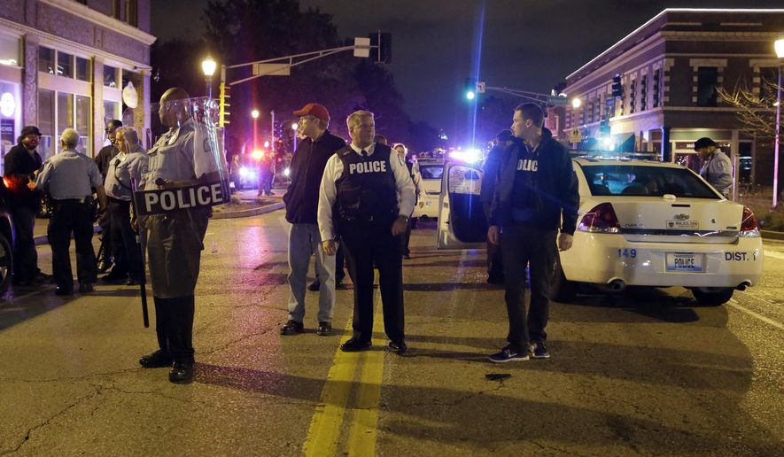 St. Louis Police Chief Sam Dotson, center, stands in the middle of the street with other officers during a confrontation between protesters Thursday, Oct. 9, 2014, a day after Vonderrit D. Myers was shot and killed by white, off-duty St. Louis police officer in St. Louis. (AP Photo/Jeff Roberson) ** FILE **