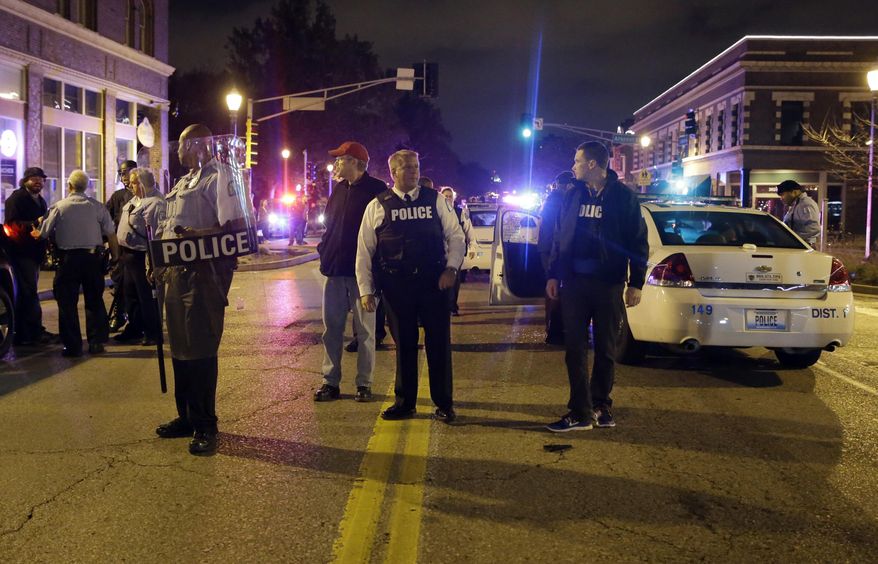 St. Louis Police Chief Sam Dotson, center, stands in the middle of the street with other officers during a confrontation between protesters Thursday, Oct. 9, 2014, a day after Vonderrit D. Myers was shot and killed by white, off-duty St. Louis police officer in St. Louis. (AP Photo/Jeff Roberson) ** FILE **