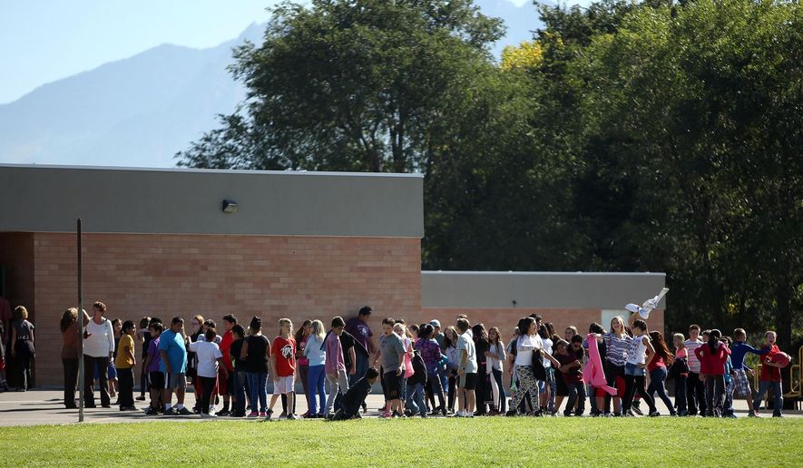 FILE - In this Sept. 11, 2014 file photo, students line up to go back inside after recess at Westbrook Elementary School in Taylorsville, Utah. A Utah schoolteacher who was injured by fragments from a bullet and a porcelain toilet when her gun accidentally went off in a faculty bathroom has been charged with a misdemeanor and resigned. Online court records show 39-year-old Michelle Montgomery was charged this month with discharge of a firearm in a prohibited area within city limits. An arraignment is scheduled for Nov. 5.(AP Photo/The Deseret News, Kristin Murphy, File) SALT LAKE TRIBUNE OUT; MAGS OUT