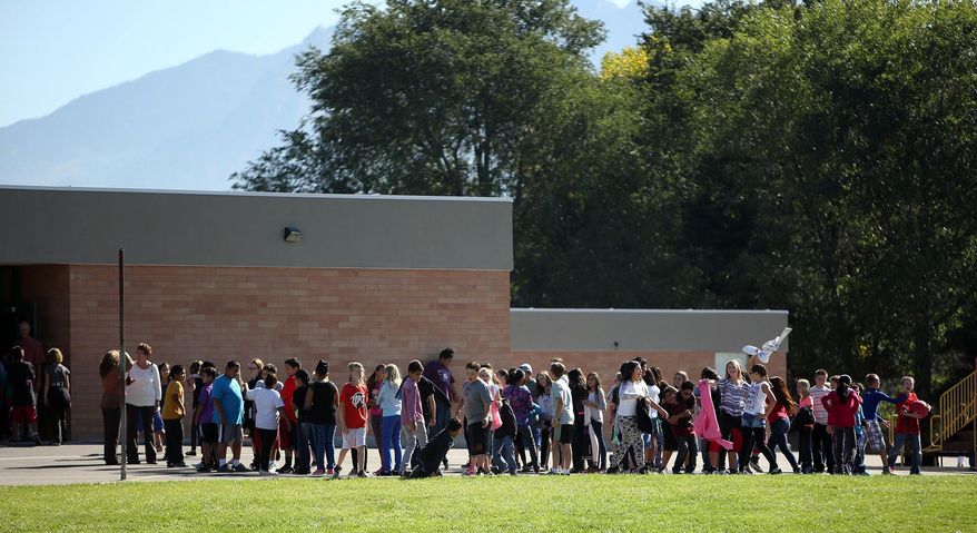FILE - In this Sept. 11, 2014 file photo, students line up to go back inside after recess at Westbrook Elementary School in Taylorsville, Utah. A Utah schoolteacher who was injured by fragments from a bullet and a porcelain toilet when her gun accidentally went off in a faculty bathroom has been charged with a misdemeanor and resigned. Online court records show 39-year-old Michelle Montgomery was charged this month with discharge of a firearm in a prohibited area within city limits. An arraignment is scheduled for Nov. 5.(AP Photo/The Deseret News, Kristin Murphy, File) SALT LAKE TRIBUNE OUT; MAGS OUT