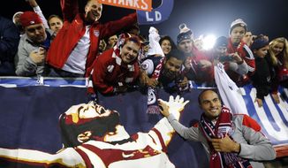United States&#x27; Landon Donovan, bottom right, celebrates with fans after an exhibition soccer match against Ecuador in East Hartford, Conn., Friday, Oct. 10, 2014. Donovan made his last international soccer appearance Friday. (AP Photo/Elise Amendola)