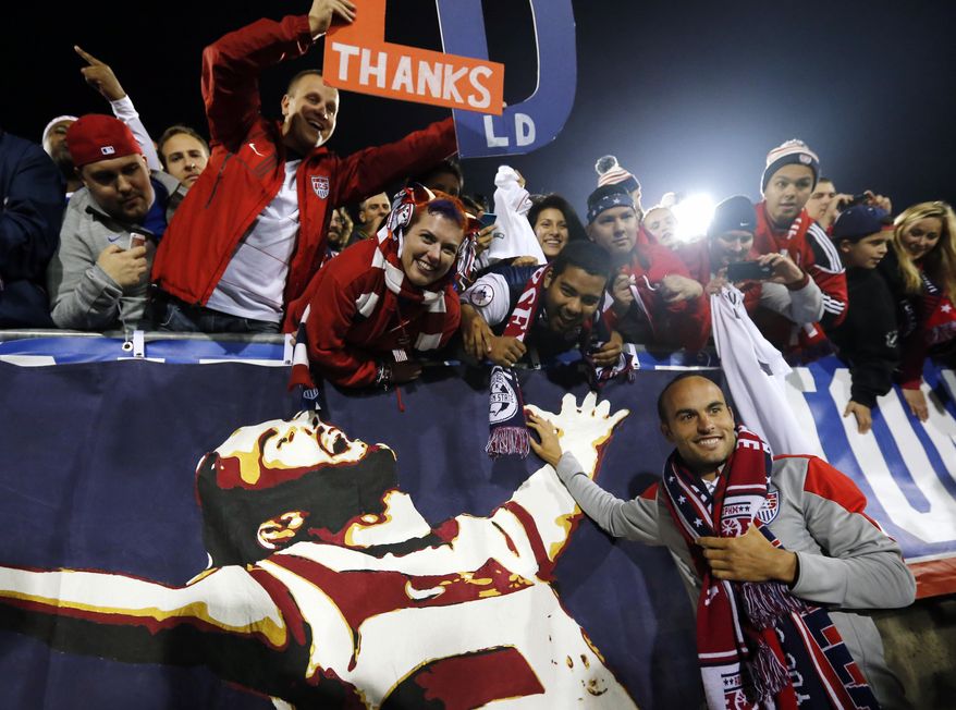 United States' Landon Donovan, bottom right, celebrates with fans after an exhibition soccer match against Ecuador in East Hartford, Conn., Friday, Oct. 10, 2014. Donovan made his last international soccer appearance Friday. (AP Photo/Elise Amendola)