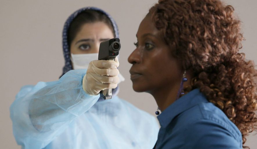 A Moroccan health worker uses a thermometer to screen a passenger at the arrivals hall of the Mohammed V airport in Casablanca, on Thursday, Oct 9, 2014. Airline passengers arriving in the U.S. from three West African countries will face temperature checks using no-touch thermometers and other screening measures at five American airports, starting with New York’s Kennedy on Saturday, Oct. 10, 2014. (AP Photo/The Canadian Press, Abdeljalil Bounhar) **FILE**