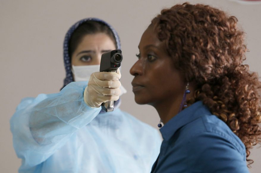 A Moroccan health worker uses a thermometer to screen a passenger at the arrivals hall of the Mohammed V airport in Casablanca, on Thursday, Oct 9, 2014. Airline passengers arriving in the U.S. from three West African countries will face temperature checks using no-touch thermometers and other screening measures at five American airports, starting with New York’s Kennedy on Saturday, Oct. 10, 2014. (AP Photo/The Canadian Press, Abdeljalil Bounhar) **FILE**
