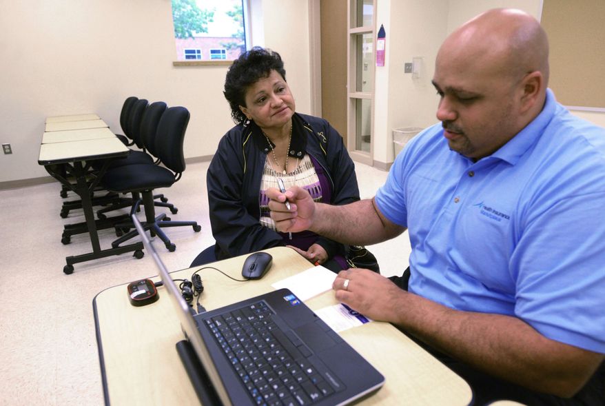 Else Trinidad gets help  from Omar Bonet of SRA international about information regarding ACA health insurance options in Paterson, NJ, Friday, Oct. 10, 2014. (AP Photo/The Record of Bergen County, Viorel Florescu) (AP Photo/The Record, VIOREL FLORESCU)