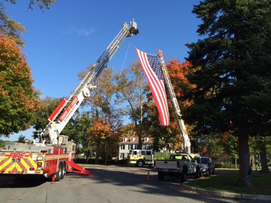 An American flag is draped from two fire trucks during the national memorial ceremony for fallen firefighters in Emmitsburg, Md., Sunday, Oct. 12, 2014. U.S. Rep. Steny Hoyer delivered the keynote address. Among the 107 firefighters honored were 19 Arizona firefighters killed in a 2013 canyon fire and 10 first responders killed in a fertilizer plant explosion in Central Texas last year. Ninety-eight of the firefighters honored died in the line of duty in 2013. Nine died in previous years. (AP Photo/PennLive.com, Ivey DeJesus)