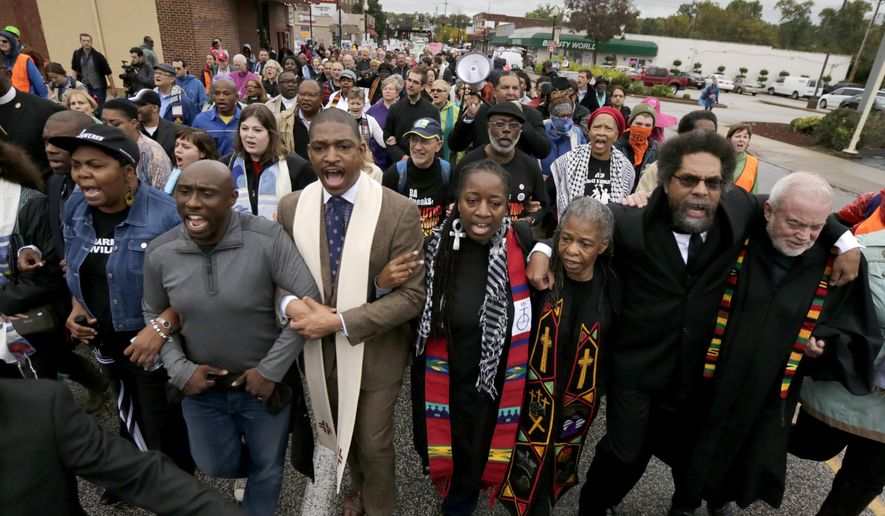Protesters, including Cornel West, second from right, march to the Ferguson, Mo., police station, Monday, Oct. 13, 2014, in Ferguson. Activists planned a day of civil disobedience to protest the shooting of Michael Brown, in August, and a second police shooting in St. Louis last week. (AP Photo/Charles Rex Arbogast)