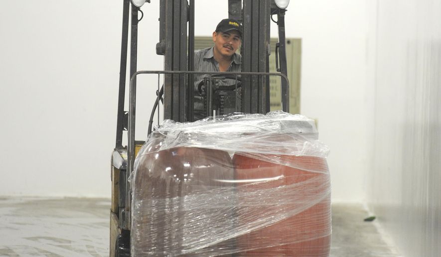 Gielow shipping and receiving supervisor Edgar Campgne brings containers of fermented sour kraut to the chill room Wednesday, Oct 8, 2014 at the company's facility at the Port of Skagit. (AP Photo/Skagit Valley Herald, Scott Terrell)