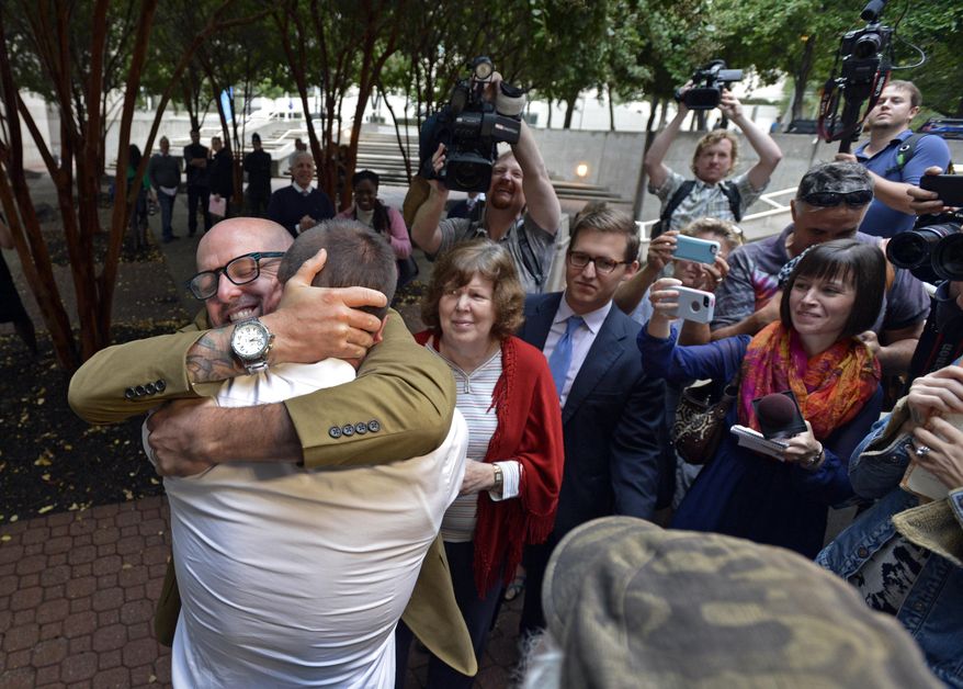 The scene outside the Mecklenburg County's Register of Deeds office as Joey Hewell and Scott Lindsley embrace after being married Monday, Oct. 13, 2014, in Charlotte, N.C. (AP Photo/The Charlotte Observer, Davie Hinshaw)