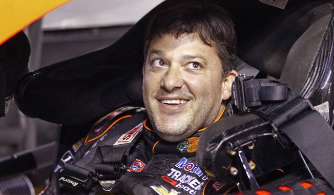 Tony Stewart smiles as he sits in his car before qualifying for Saturday&#x27;s NASCAR Bank of America Sprint Cup series auto race at Charlotte Motor Speedway in Concord, N.C., Thursday, Oct. 9, 2014. (AP Photo/Terry Renna)