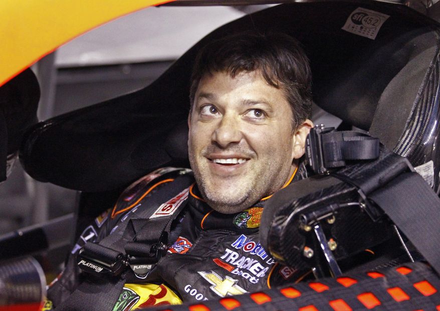 Tony Stewart smiles as he sits in his car before qualifying for Saturday&#x27;s NASCAR Bank of America Sprint Cup series auto race at Charlotte Motor Speedway in Concord, N.C., Thursday, Oct. 9, 2014. (AP Photo/Terry Renna)
