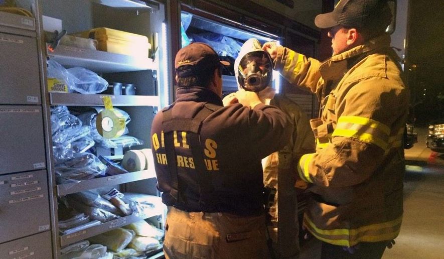 Members of Dallas Fire-Rescue Department prepare to decontaminate common areas near the Dallas apartment of a second health care worker who has tested positive for Ebola. (Associated Press) ** FILE **