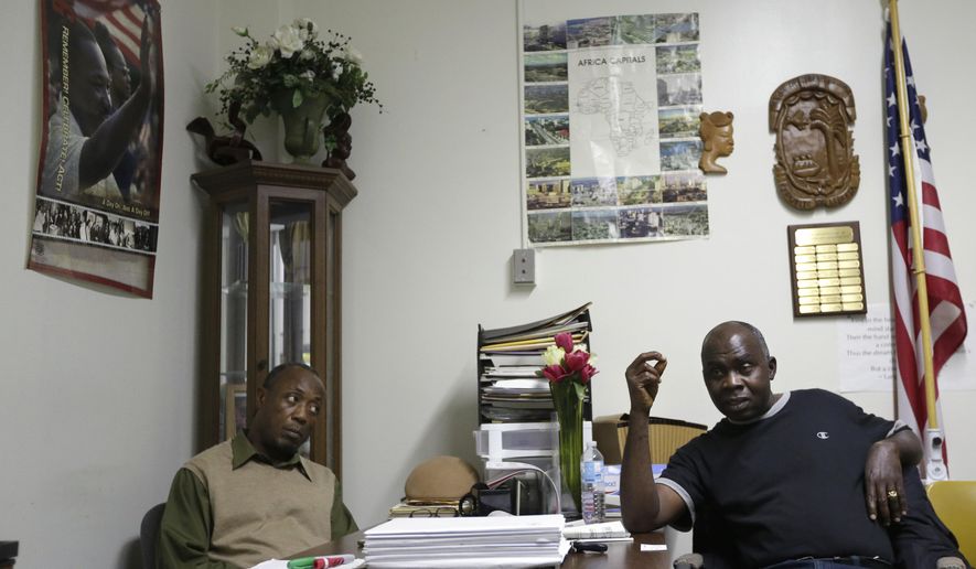In this Wednesday, Oct. 8, 2014 photo, Winston Gould, left, president of the Liberian Community Association of Rhode Island, listens to newspaper publisher Jacob Dorbor, right, during a meeting of the association, in Providence, R.I. Rhode Island’s close-knit Liberian community is trying to strike a balance between their longstanding tradition of hospitality and the fear of infection from Ebola's spread. (AP Photo/Steven Senne)