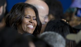 First lady Michelle Obama meets with audience members as she campaigns for Pennsylvania Democratic gubernatorial candidate Tom Wolf, center right, Wednesday, Oct. 15, 2014, at the Dorothy Emanuel Recreation Center in Philadelphia. (AP Photo/Matt Rourke)