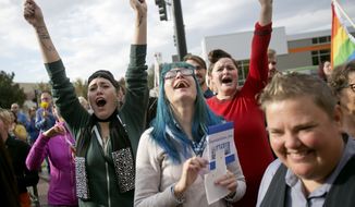 Well-wishers yell encouragement to same sex couples, including Karen McMillan, right, make their way out of the Ada County Courthouse after they received their marriage license, Wednesday, Oct. 15, 2014, in Boise, Idaho. (AP Photo/The Idaho Statesman, Kyle Green)  LOCAL TELEVISION OUT (KTVB 7); MANDATORY CREDIT