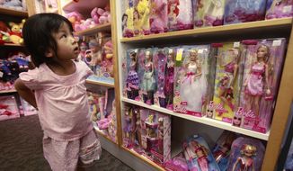 FILE - In this July 14, 2010 file photo, Avi Yisrael, 3, looks at Barbie Dolls, which are produced by Mattel, at a toy store in Palo Alto, Calif. Mattel on Thursday, Oct. 16, 2014 reported that Barbie sales fell 21 percent for the three months ended Sept. 30, 2014, even sharper than the 15 percent drop in the second quarter. (AP Photo/Paul Sakuma, File) **FILE**