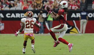 Arizona Cardinals wide receiver Larry Fitzgerald (11) pulls in a pass as Washington Redskins strong safety Bashaud Breeland (26) defends during the second half of an NFL football game, Sunday, Oct. 12, 2014, in Glendale, Ariz.(AP Photo/Rick Scuteri) 
