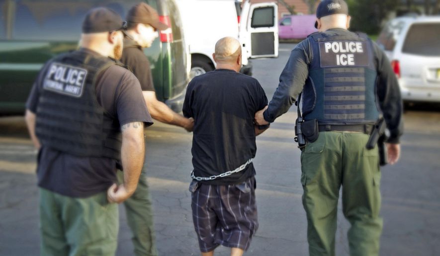 In this Tuesday, Oct. 14, 2014 photo provided by the U.S. Bureau of Immigration and Customs Enforcement (ICE), agents take a person into custody during an immigration sweep in Ontario, Calif. Immigration officials say local authorities across the U.S. released thousands of immigrants from jails this year despite efforts to take them into federal custody, including more than 3,000 with previous felony charges or convictions. They highlight the friction between the federal government and police and sheriff's departments, some of which say holding immigrants beyond their release dates harms community policing efforts. (AP Photo/U.S. Bureau of Immigration and Customs Enforcement)