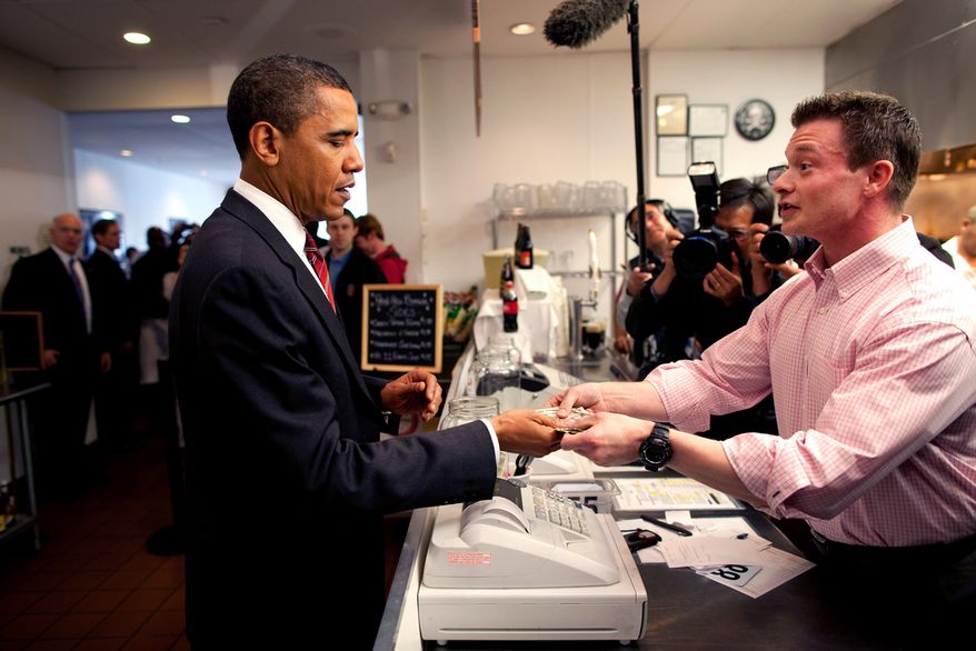 President Barack Obama gets his change after paying for his lunch as he and Vice President Joe Biden make an unannounced visit to Ray&#39;s Hell Burger in Arlington, Va., May 5, 2009. White House photo.