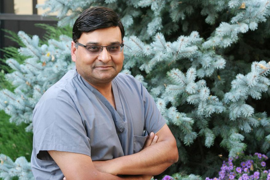 In this photo taken on Sept. 30, 2014, Dr. Mukesh Garg poses for a photo outside Mary Lanning Memorial Healthcare hospital in Hasting, Neb. (AP Photo/The Hastings Tribune, John Huthmacher)