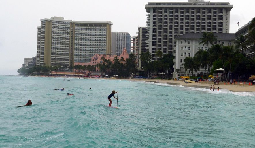 A paddle boarder heads to shore at Waikiki Beach in Honolulu, Hawaii on Saturday, Oct. 18, 2014, as Hurricane Ana passes southwest of Hawaii. (AP Photo/Cathy Bussewitz)