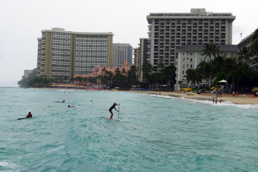 A paddle boarder heads to shore at Waikiki Beach in Honolulu, Hawaii on Saturday, Oct. 18, 2014, as Hurricane Ana passes southwest of Hawaii. (AP Photo/Cathy Bussewitz)