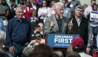 Democratic candidates James Lee Witt, left, and Mike Ross, right, watch former President Bill Clinton speak to the crowd during a rally at the train depot in his hometown of Hope, Ark. Saturday, Oct, 18, 2014. Clinton praised all of the democratic candidates up for election and touched on topics such as the Ebola and healthcare.  (AP Photo/Texarkana Gazette, Jerry Habraken)
