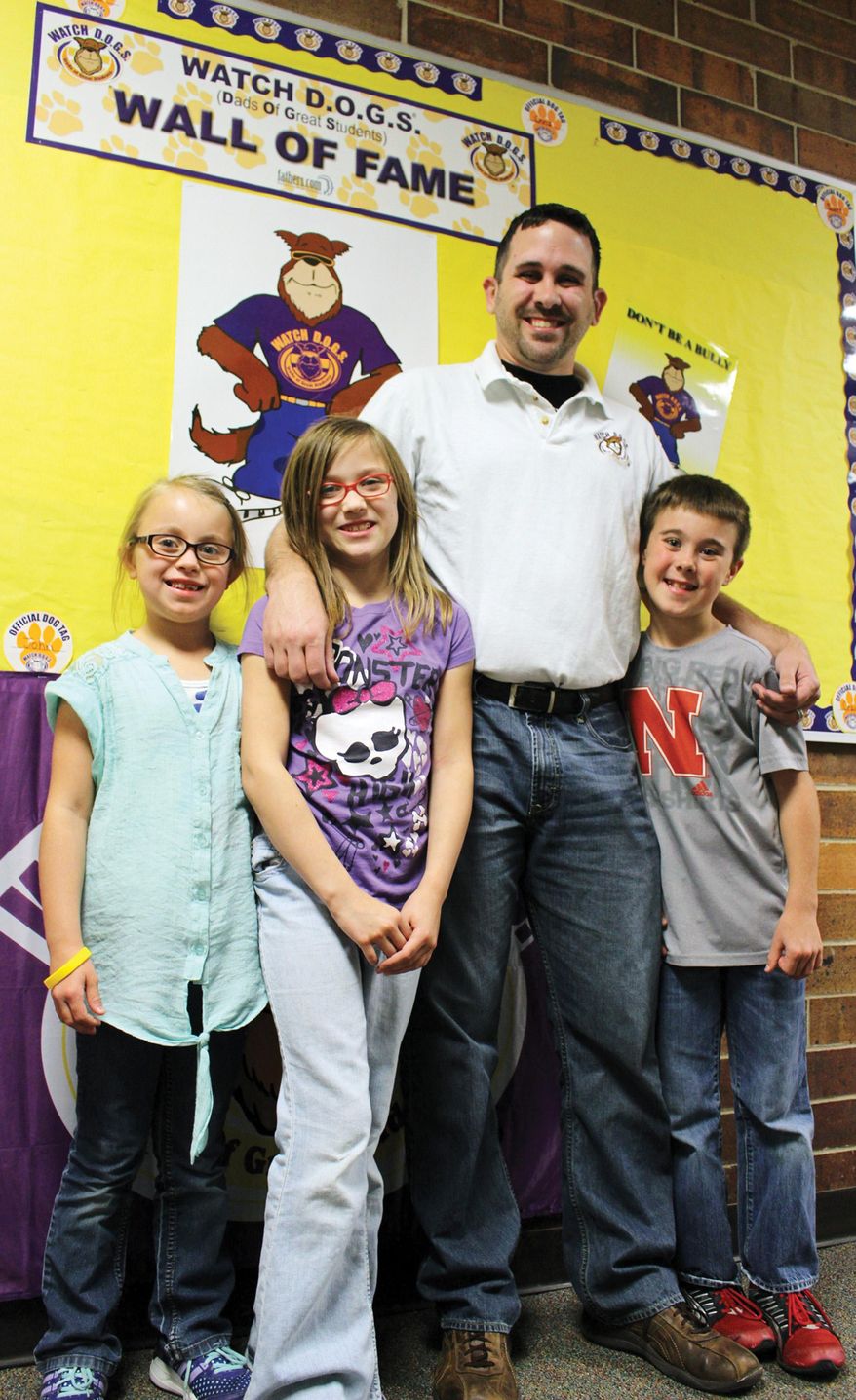 In this Oct. 8, 2014, photo, parent John Lee, a leader of the Northeast Elementary School Watch Dads of Great Students group in Glenwood, Iowa, stands with his children, from left, Abbi Driscoll, Caitlyn Lee and Anthony Driscoll. The group brings fathers into school buildings to be role models, help students and be an extra pair of eyes to keep schools safe. (AP Photo/The Daily Nonpareil, Scott Stewart)