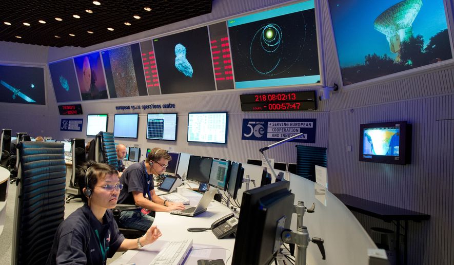Experts watch their screens at the control center of the European Space Agency, ESA, in Darmstadt, Germany during a mission to land the first space probe on a comet. (AP Photo/dpa, Boris Roessler)