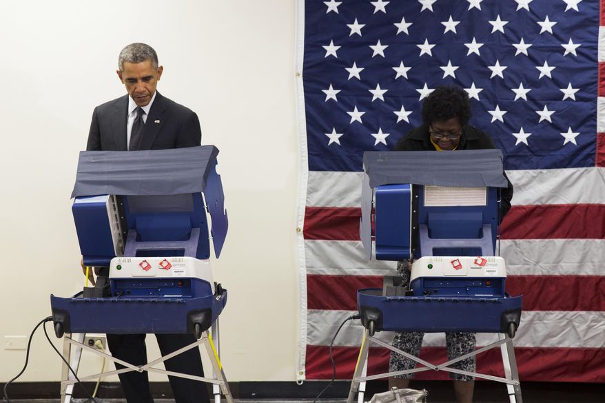 President Barack Obama, left, cast a ballot for the 2014 midterm elections at the Dr. Martin Luther King Community Service Center while participating in early voting on Monday, Oct. 20, 2014, in Chicago. Obama took a break from campaigning for Gov. Pat Quinn, D-Ill., to cast an early ballot for the election. (AP Photo/Evan Vucci)