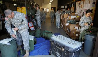 Soldiers from the 35th Theater Tactical Signal Brigade pack their gear as they prepare for deployment to west Africa to aid against the spread of the Ebola virus in Fort Gordon, Ga., Monday, Oct. 20, 2014. (AP Photo/The Augusta Chronicle, Michael Holahan)