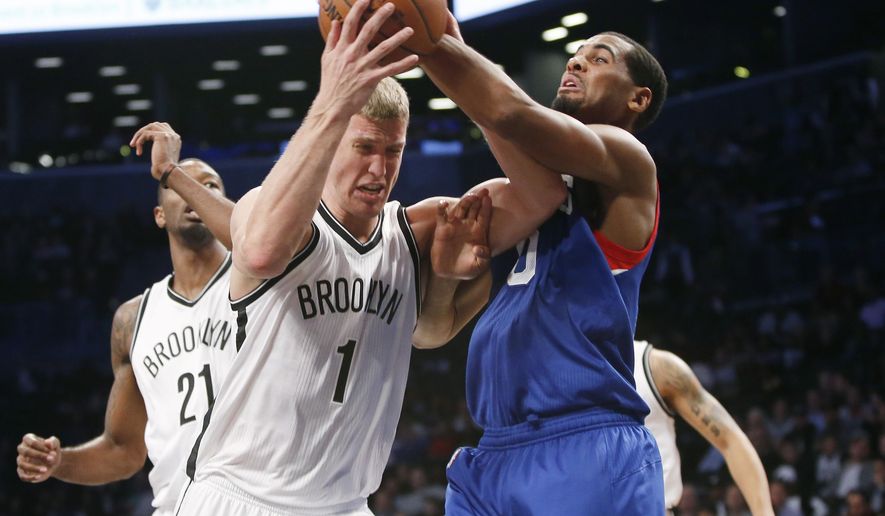 Brooklyn Nets forward Mason Plumlee (1) struggles to hold onto the ball after pulling a rebound as Philadelphia 76ers forward Brandon Davies (0) tries to strip the ball from him in the first half of an NBA basketball game at the Barclays Center, Monday, Oct. 20, 2014, in New York. (AP Photo/Kathy Willens)