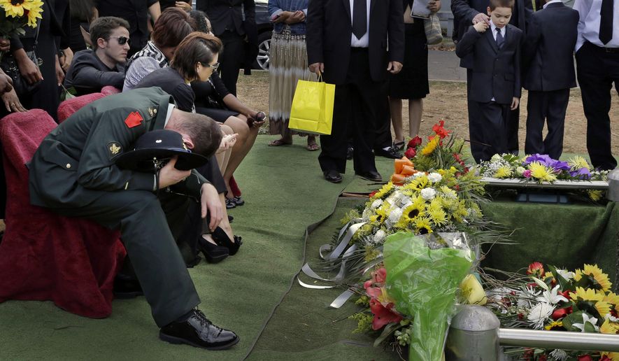 ADVANCE FOR USE SUNDAY, OCT. 26, 2014, AND THEREAFTER- In this Sept. 5, 2014 photo, Glen Carter, a 33-year-old Army veteran, morns as the casket of his girlfriend Maria Fernandes is lowered into the ground during her funeral service in Linden, N.J. Fernandes died while napping in her car between one of her three jobs. Police said it appears Fernandes was overcome by a deadly mixture of carbon monoxide and fumes from an overturned gasoline container. (AP Photo/Mel Evans)