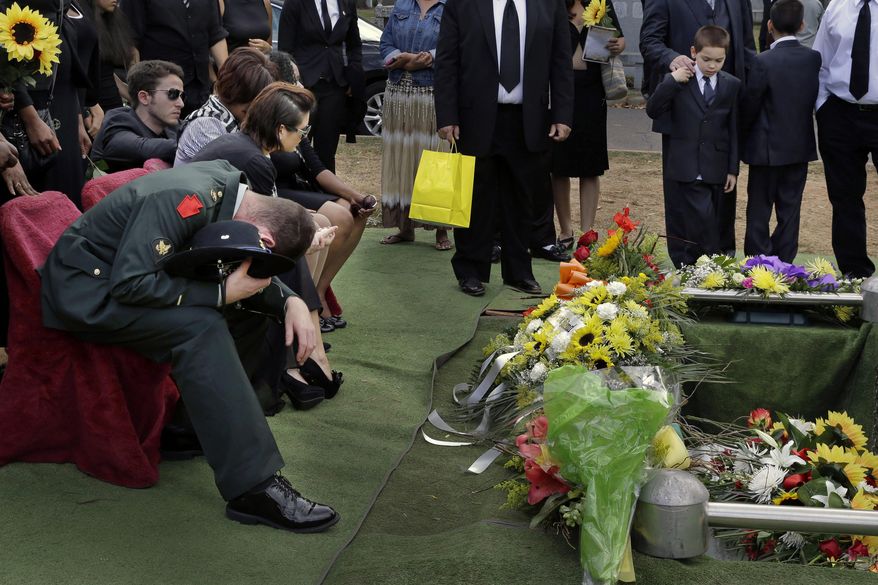 ADVANCE FOR USE SUNDAY, OCT. 26, 2014, AND THEREAFTER- In this Sept. 5, 2014 photo, Glen Carter, a 33-year-old Army veteran, morns as the casket of his girlfriend Maria Fernandes is lowered into the ground during her funeral service in Linden, N.J. Fernandes died while napping in her car between one of her three jobs. Police said it appears Fernandes was overcome by a deadly mixture of carbon monoxide and fumes from an overturned gasoline container. (AP Photo/Mel Evans)